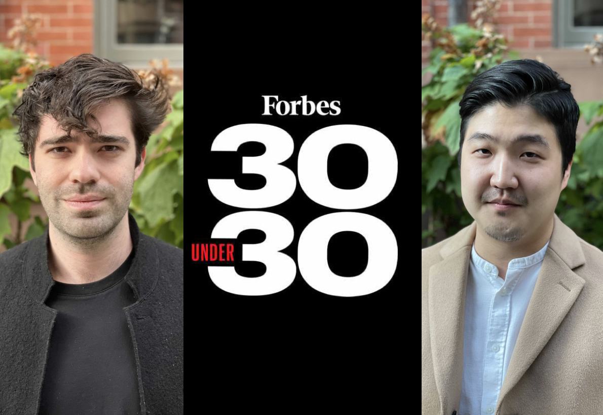 Two young men stand outdoors with greenery in the background, flanking a black Forbes 30 Under 30 logo.